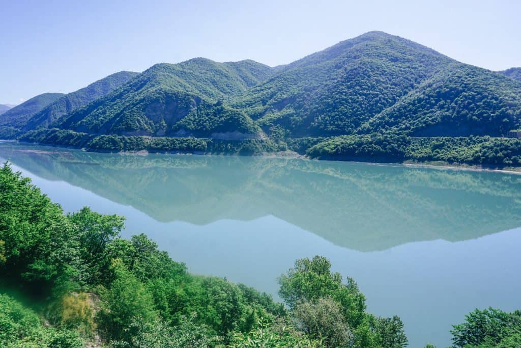 Weekend guide to Georgia with a large body of water amidst surrounding mountains.