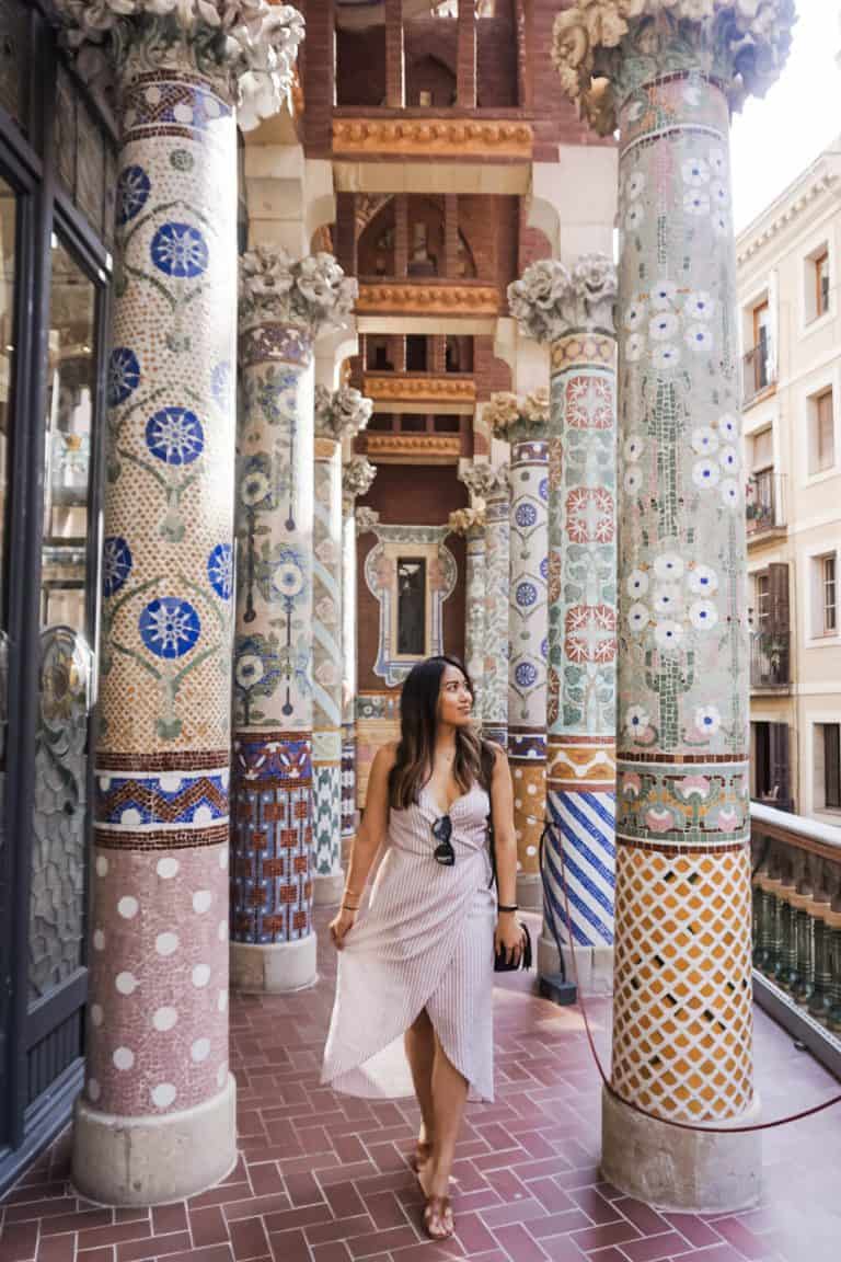 a woman in a white dress walking through a building in Barcelona.