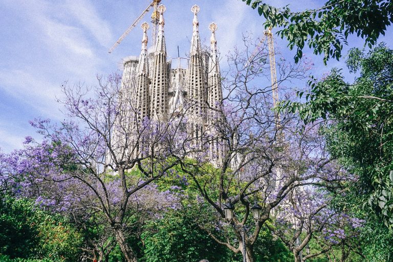 A towering edifice surrounded by lush foliage in the heart of Barcelona, Spain.