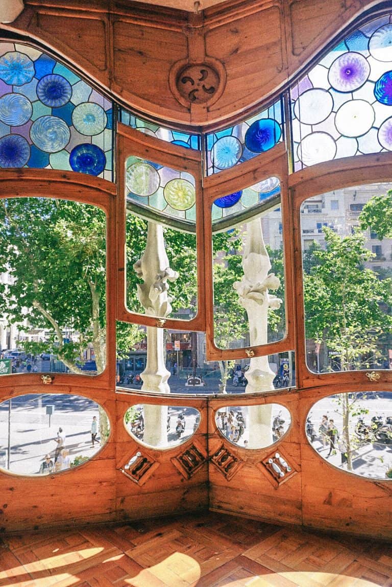 A room with stained glass windows and a statue in the corner in Barcelona, Spain.