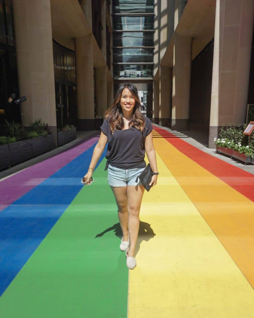 A woman walking down a rainbow-colored walkway at Pride in London 2023.