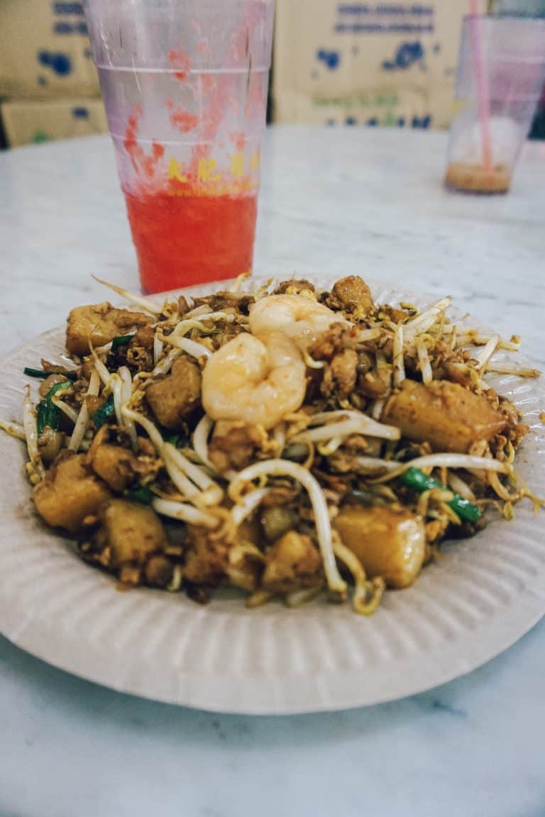 A plate of food and drink on a table in Penang.