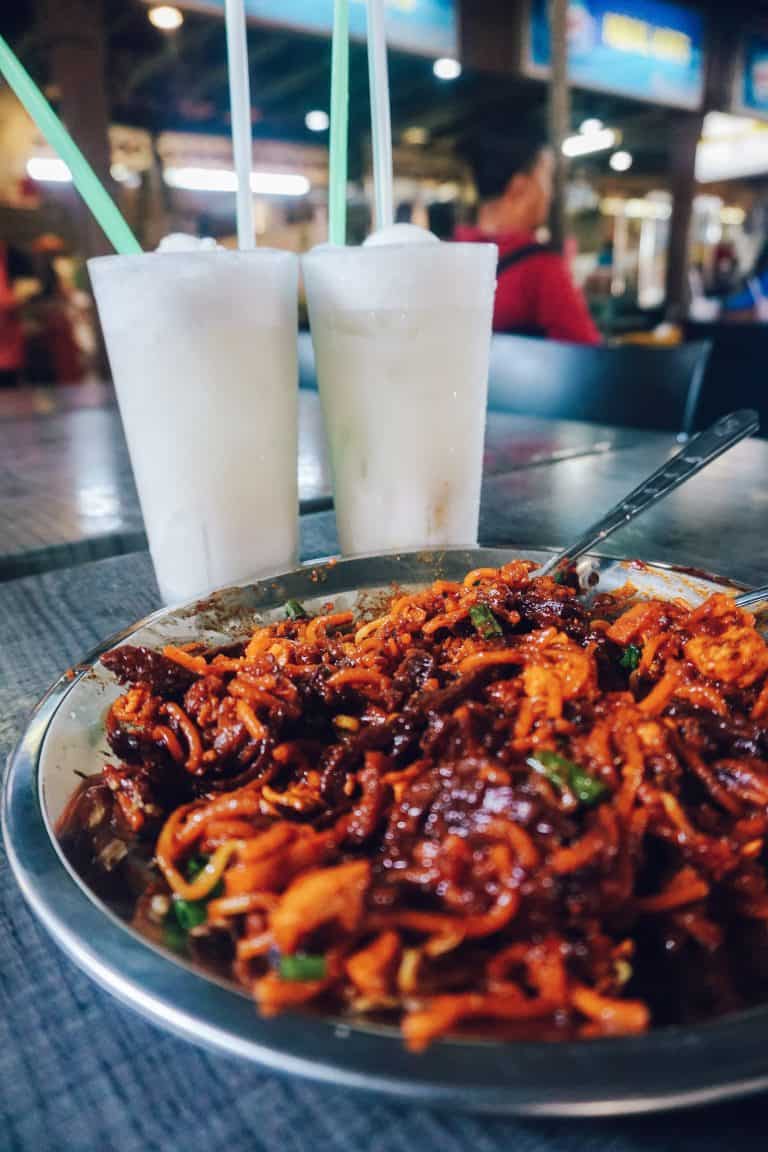 A plate of food and two drinks on a table in Penang, Malaysia.