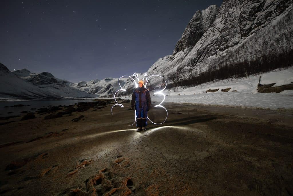 a person standing in a snow covered field in Tromso.