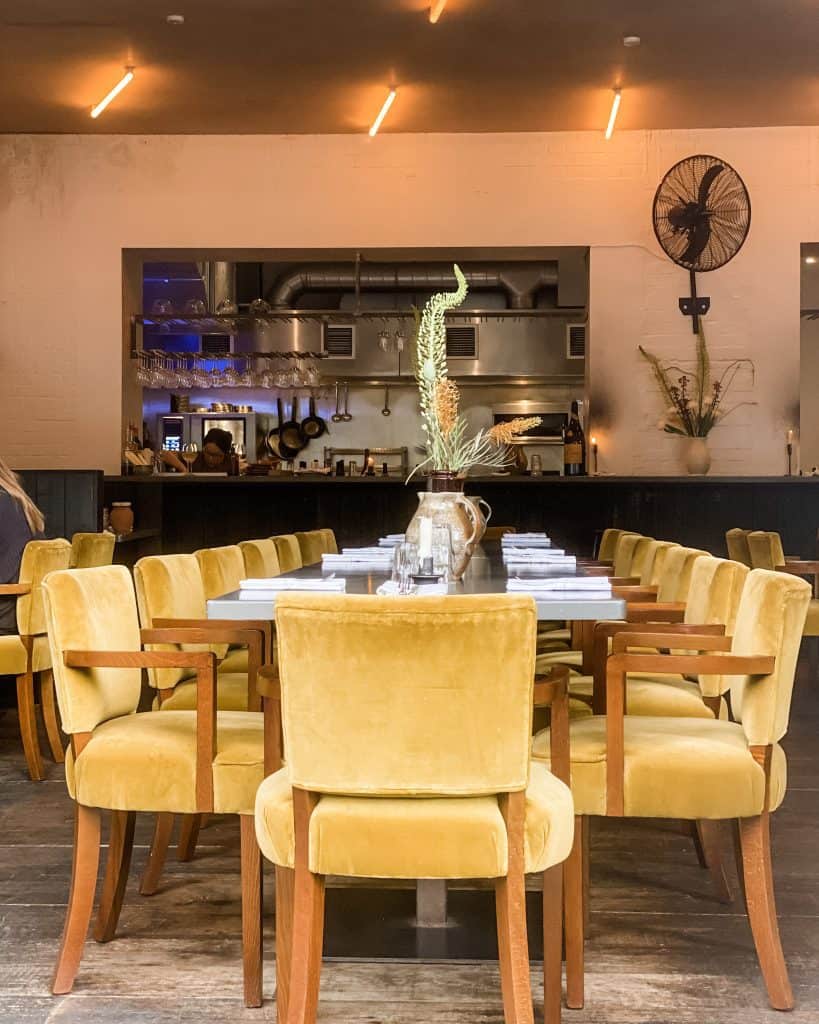 a dining room with yellow chairs and a table.