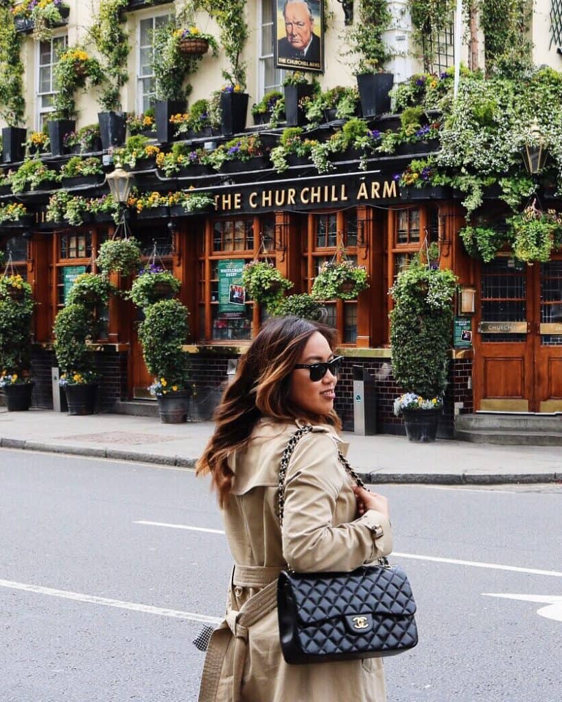 Is London Safe A picture of Denise Cas crossing road in london with a chanel bag to show to be weary of fake luxury good scams 