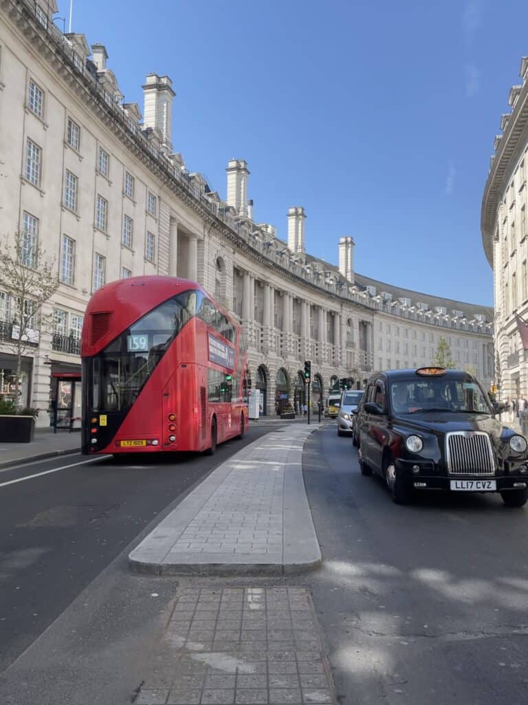Is London Safe - A bus and a black cab driving through regent street from the middle of the road to show you to be careful when crossing the roads in London 