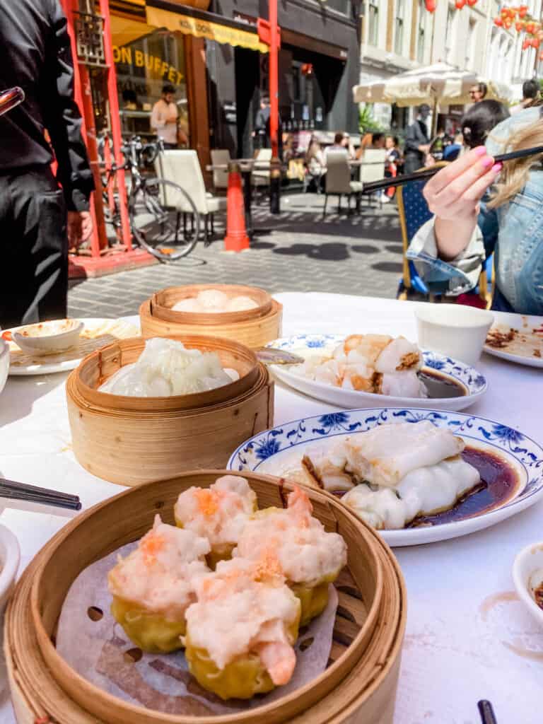 a woman sitting at a table with food on it.